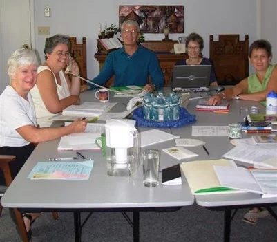 A regionally based DUCC working group, some gather around the table in Winnipeg and others join in by phone.